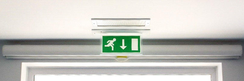 Illuminated fire exit sign next to a door