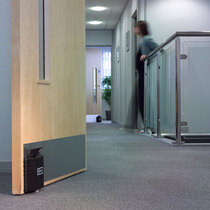 Plunger, with rubber ferrule, grips onto floor to hold door open